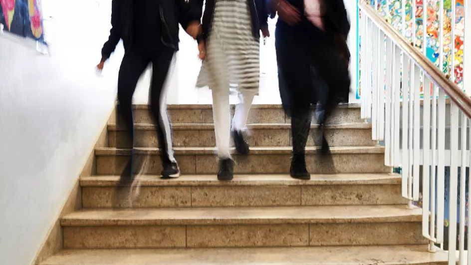 tre elever går nedad trappe